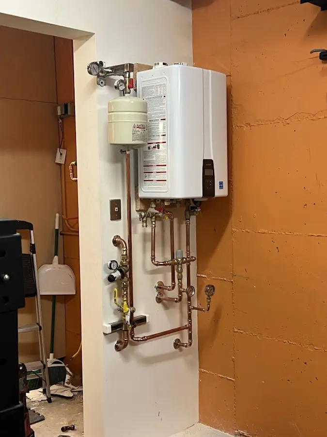 Plumbing technician inspecting water heater connections in Springville